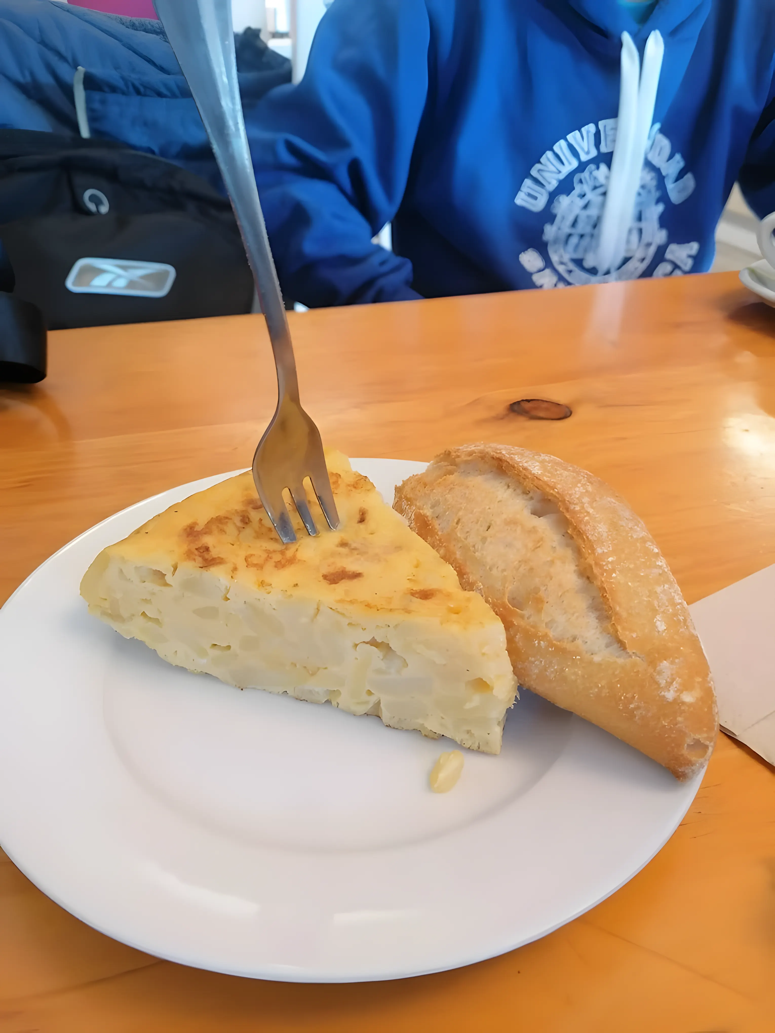 Slice of potato tortilla with bread at Goxune